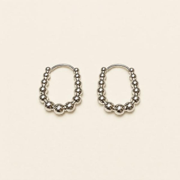 Silver-tone beaded hoop earrings on a neutral background