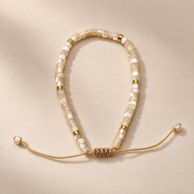 Ivory beaded bracelet with gold-tone spacers and an adjustable cord